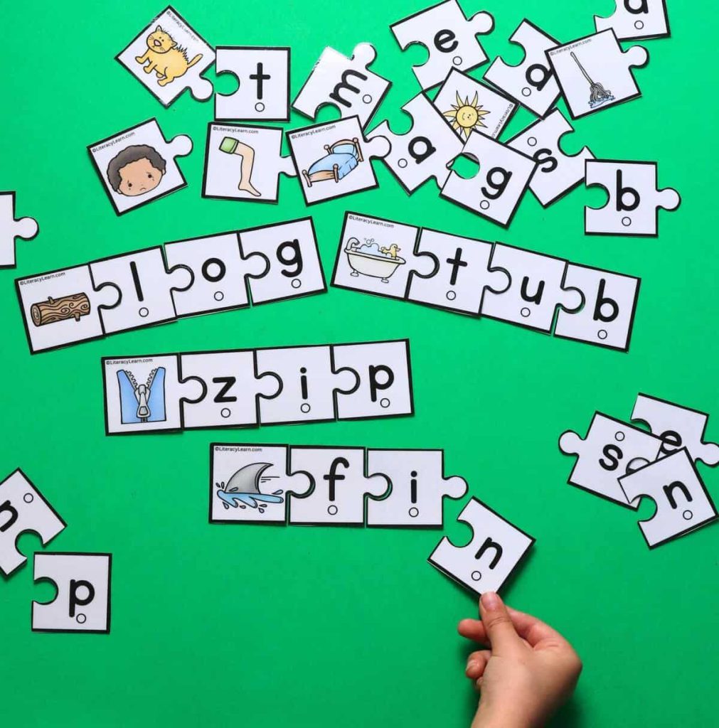 A child putting CVC puzzle pieces together to make the word "fin."
